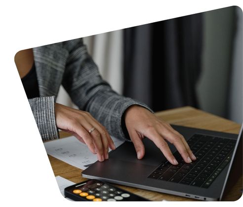 doing payroll on a laptop with a calculator